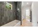 Bathroom with gray vertical tile and white tub at 5601 Robinhood Rd, Charlotte, NC 28211