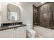 Elegant bathroom with a black countertop vanity, a tub with tile surround, and modern fixtures at 5601 Robinhood Rd, Charlotte, NC 28211