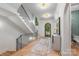 Spacious foyer featuring a grand staircase, hardwood floors, and a modern light fixtures at 5601 Robinhood Rd, Charlotte, NC 28211