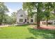 Stately home with white brick, arched entry, manicured lawn, and professionally landscaped front yard at 5601 Robinhood Rd, Charlotte, NC 28211