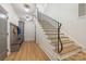 Elegant hallway with wood staircase, iron railing, and custom built-in bench and storage unit at 5601 Robinhood Rd, Charlotte, NC 28211