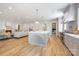Open-concept kitchen with a large island and stainless steel appliances flows into the living room with fireplace at 5601 Robinhood Rd, Charlotte, NC 28211