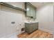 Laundry room featuring green cabinets, a sink, and hardwood floors at 5601 Robinhood Rd, Charlotte, NC 28211