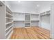 Spacious walk-in closet with custom shelving, hardwood flooring, and recessed lighting at 5601 Robinhood Rd, Charlotte, NC 28211