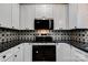 Well-lit kitchen features modern appliances, black countertops, and custom starburst backsplash at 600 S Cline Ave, Newton, NC 28658