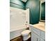 Bathroom features a white bathtub, a toilet, a vanity sink, and green walls at 664 Cape Fear St, Fort Mill, SC 29715