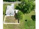 An aerial view of the property featuring a white house, fenced-in yard, and mature trees at 711 Wood St, Albemarle, NC 28001