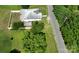 This aerial view of the property shows a white home, partially fenced yard, trees and nearby street at 711 Wood St, Albemarle, NC 28001
