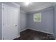 This bedroom features light gray walls, a window, and new flooring at 711 Wood St, Albemarle, NC 28001