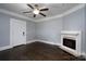 Bright living room featuring dark wood floors, a ceiling fan, a fireplace and white trim at 711 Wood St, Albemarle, NC 28001