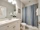 Bright bathroom featuring a white vanity, framed mirror, and a shower with a blue-patterned curtain at 809 River Park Rd, Belmont, NC 28012