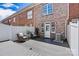 Private brick-walled backyard featuring an outdoor seating area with two chairs and a small black table at 110 Dime Ln, Mooresville, NC 28117