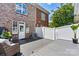 Private brick-walled backyard featuring a white privacy fence and an outdoor seating area with chairs at 110 Dime Ln, Mooresville, NC 28117