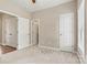 Neutral carpeted bedroom featuring three doors, one leading to another room and one to the closet at 110 Dime Ln, Mooresville, NC 28117