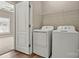 A clean laundry room with a wooden floor and a washer and dryer, featuring a metal storage shelf at 110 Dime Ln, Mooresville, NC 28117