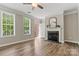 Cozy living room featuring a fireplace, wood floors, and plenty of natural light at 110 Dime Ln, Mooresville, NC 28117