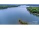 Aerial view of a vast, blue lake, surrounded by dense, green forests and a clear, blue sky at 112 S Shore Dr, Belmont, NC 28012