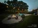 Backyard with fire pit and pool with string lights, perfect for evening entertainment at 112 S Shore Dr, Belmont, NC 28012