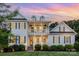 Stunning two-story home with a double porch, black shutters and a manicured lawn at dusk at 112 S Shore Dr, Belmont, NC 28012