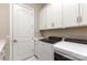 Laundry room with white cabinets and modern washer and dryer units at 112 S Shore Dr, Belmont, NC 28012