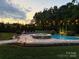 Backyard pool area with a hot tub and landscape lighting, creating a relaxing ambiance at 112 S Shore Dr, Belmont, NC 28012