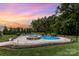 Backyard pool with a hot tub and outdoor lounge seating under a colorful sunset at 112 S Shore Dr, Belmont, NC 28012