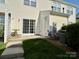 Sunny backyard patio area with white sliding glass doors at 1139 Drummond Ln, Matthews, NC 28104
