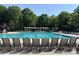 Resort style community pool surrounded by mature trees and lounge chairs at 1139 Drummond Ln, Matthews, NC 28104