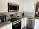 Modern kitchen with stainless steel appliances, white cabinets, and granite countertops at 1139 Drummond Ln, Matthews, NC 28104