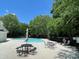 Community pool area with patio furniture, surrounded by lush greenery on a sunny day at 117 Marakery Rd # B, Mooresville, NC 28115