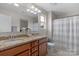 Bathroom featuring a dual sink vanity with granite countertops, wood cabinetry, and a shower at 1177 Bannockburn Ave, Rock Hill, SC 29732