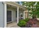 Charming front porch with black door, white columns, rocking chair, and attractive landscaping at 1177 Bannockburn Ave, Rock Hill, SC 29732
