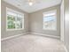 Bright bedroom with two windows providing natural light, carpet, and a ceiling fan at 132 E Morehouse Ave, Mooresville, NC 28117