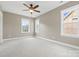 Spacious bedroom with three windows providing natural light, carpet, and a ceiling fan at 132 E Morehouse Ave, Mooresville, NC 28117