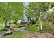 Two-story home nestled among trees with a sidewalk and mailbox in view at 132 E Morehouse Ave, Mooresville, NC 28117