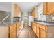 Long kitchen with oak cabinets, granite countertops, and stainless steel appliances at 132 E Morehouse Ave, Mooresville, NC 28117