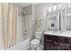 Full bathroom features a shower-tub combo with neutral-toned shower curtain, a white toilet, and single sink at 13838 Hill St, Huntersville, NC 28078