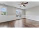 Bright bedroom features hardwood floors, ceiling fan, and large windows allowing natural light to flood the space at 13838 Hill St, Huntersville, NC 28078