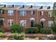Brick townhome row featuring matching doors and landscaped front yards at 13838 Hill St, Huntersville, NC 28078