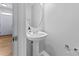 Cozy powder room features pedestal sink, oval mirror, and neutral walls, maximizing a functional space at 13838 Hill St, Huntersville, NC 28078