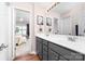 Bathroom with a double sink vanity, large mirror, and view into the adjacent bedroom at 143 Heywatchis Dr, Mooresville, NC 28115