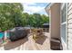 Spacious wooden deck with an outdoor dining set and a grill overlooking a lush backyard at 143 Heywatchis Dr, Mooresville, NC 28115