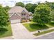 Well-manicured front yard with a two-story brick home, three car garage and inviting entrance at 143 Heywatchis Dr, Mooresville, NC 28115