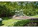 Community playground with slides, climbing structures, and benches surrounded by lush trees at 143 Heywatchis Dr, Mooresville, NC 28115