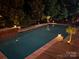 Backyard pool with garden and landscaping at night with custom landscape lighting for ambiance at 143 Heywatchis Dr, Mooresville, NC 28115