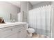 Updated bathroom with a modern vanity, sink, toilet, and a shower with a stylish curtain at 14857 Santa Lucia Dr, Charlotte, NC 28277