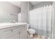 A bright bathroom featuring a gray vanity with a toilet and a shower with a patterned curtain at 14857 Santa Lucia Dr, Charlotte, NC 28277