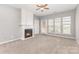 Bright living room featuring a fireplace, a ceiling fan, carpet, and natural light at 14857 Santa Lucia Dr, Charlotte, NC 28277