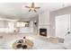 Bright living room features a fireplace, ceiling fan, and an open layout to the kitchen at 14857 Santa Lucia Dr, Charlotte, NC 28277