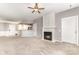 Carpeted living room featuring a fireplace, a ceiling fan, and view of the kitchen at 14857 Santa Lucia Dr, Charlotte, NC 28277